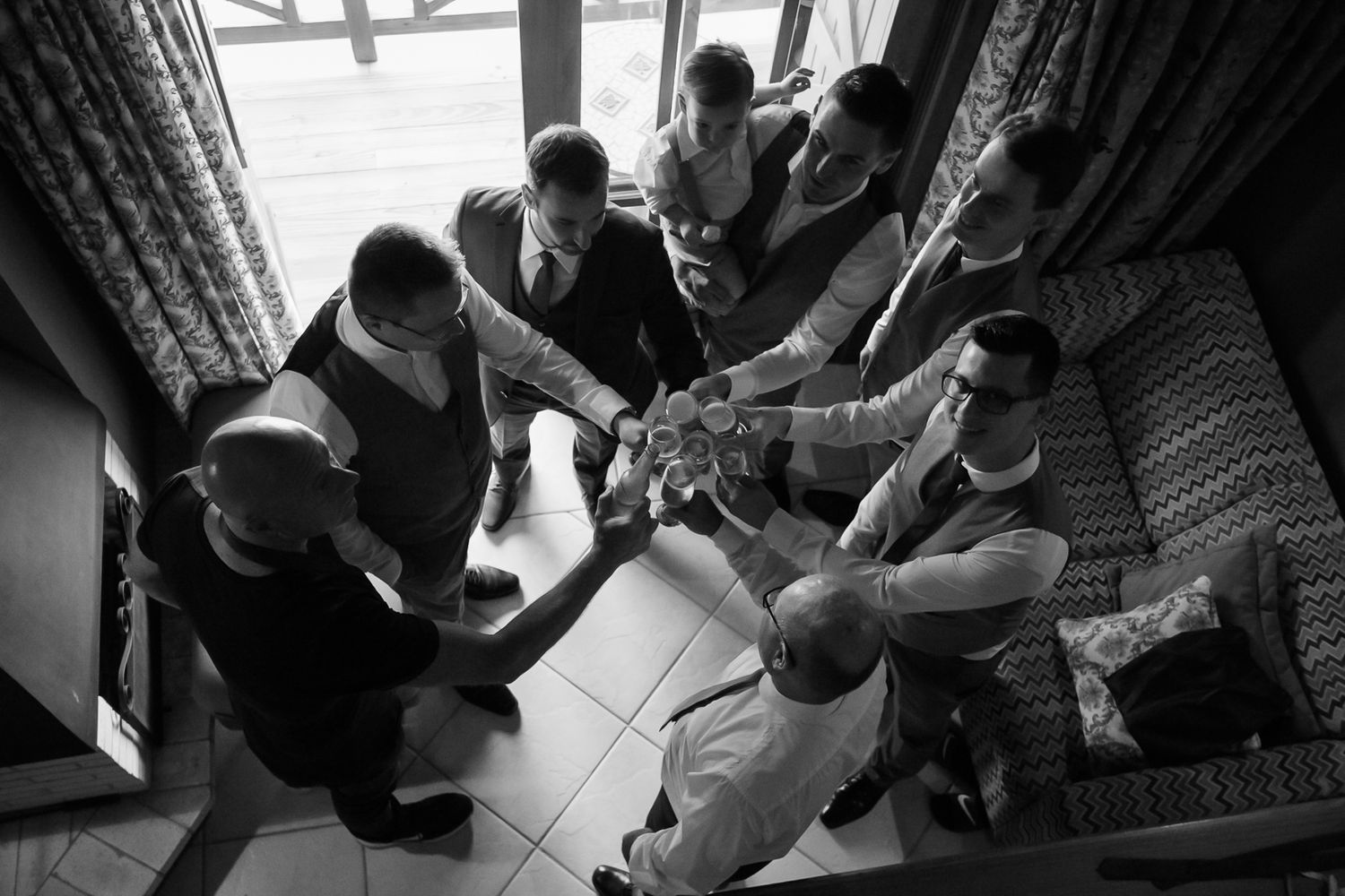 A group gathers in preparation for a wedding ceremony, shown in black and white photography.