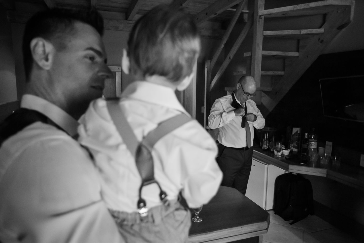 A candid black and white photo captures a moment during a wedding celebration.