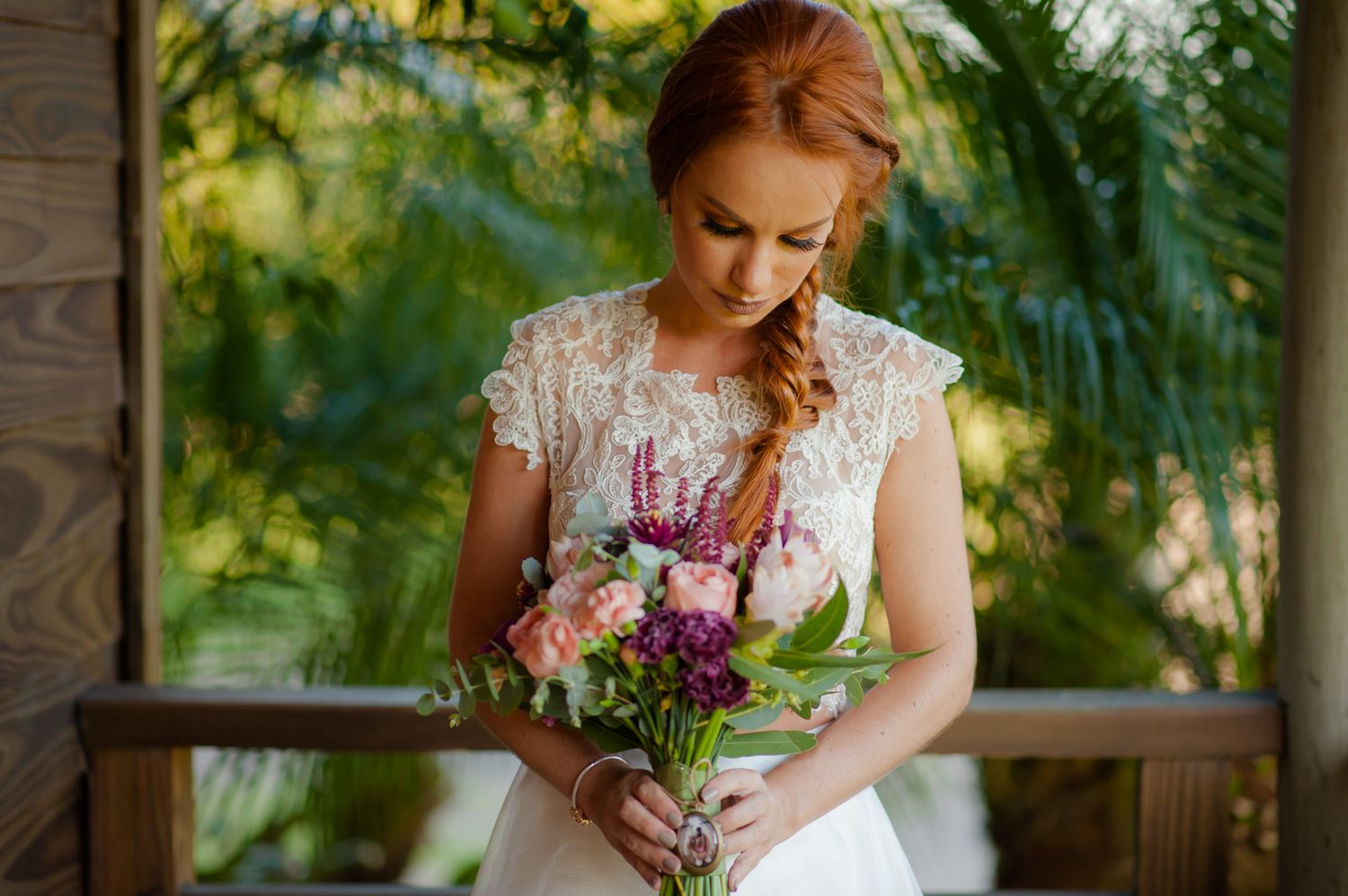 Outdoor portrait with person holding purple and pink wildflower bouquet.