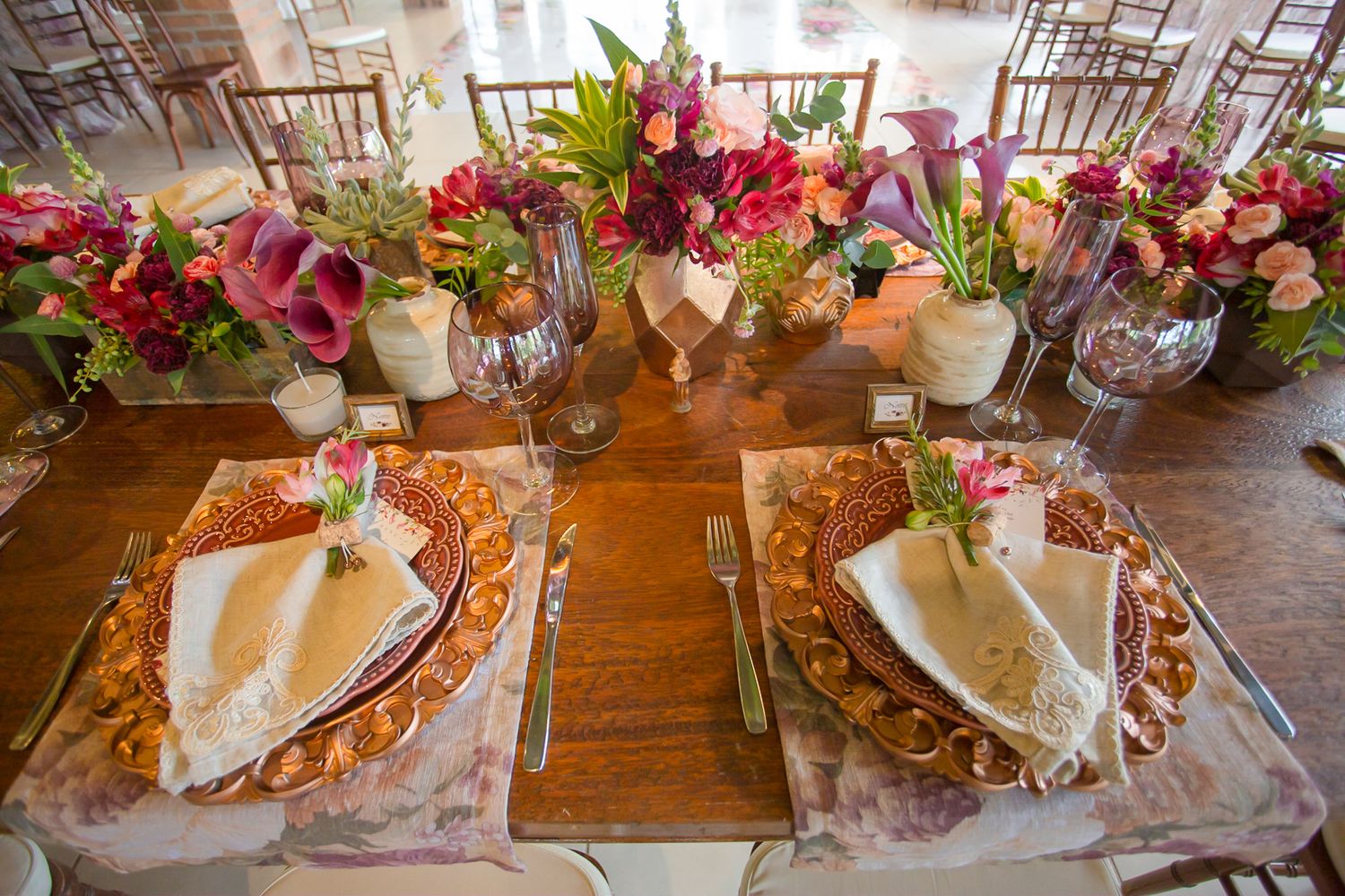 Wedding table settings with colorful floral centerpieces and decorative place settings.