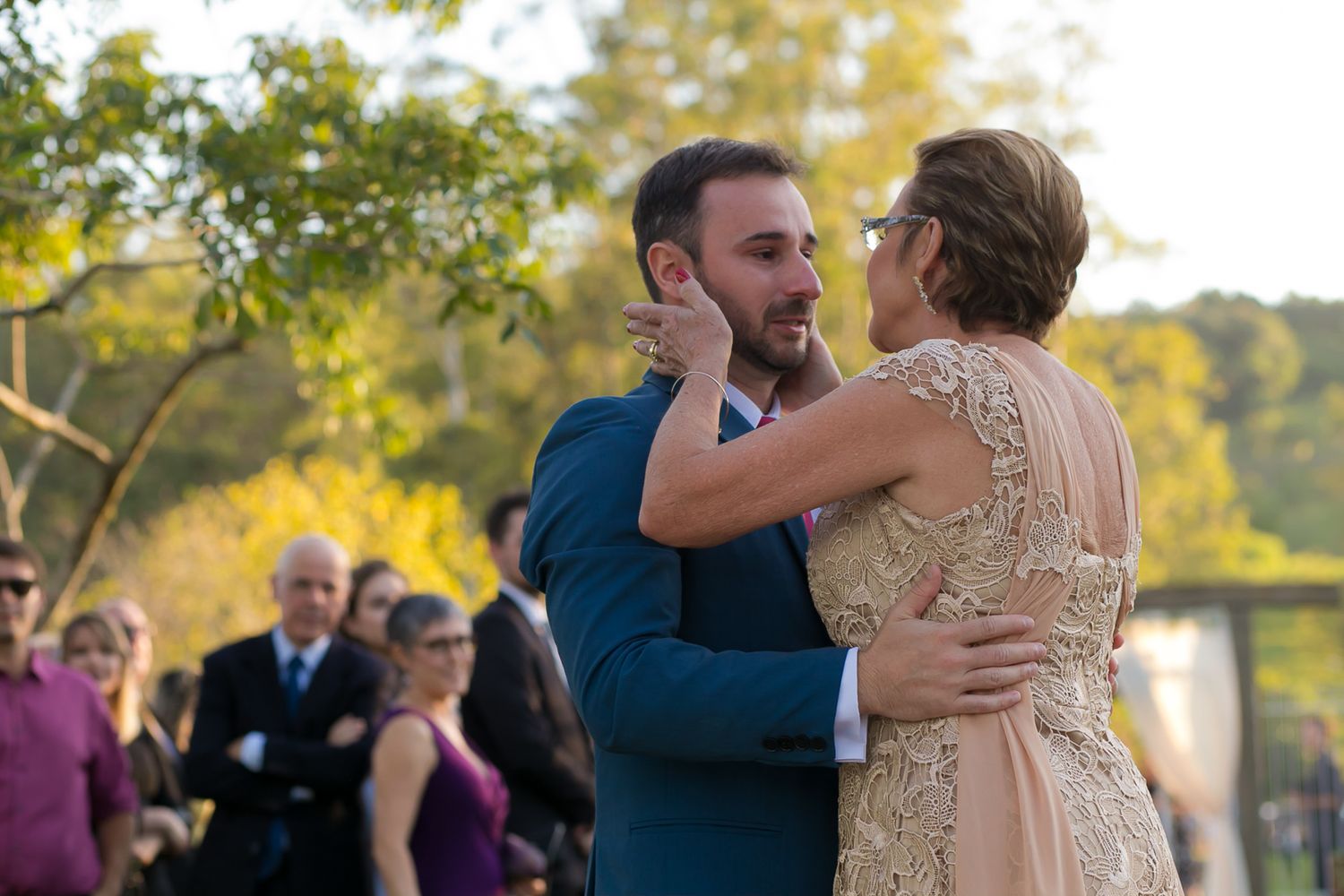 Couple sharing their first dance outdoors during golden hour at wedding reception.
