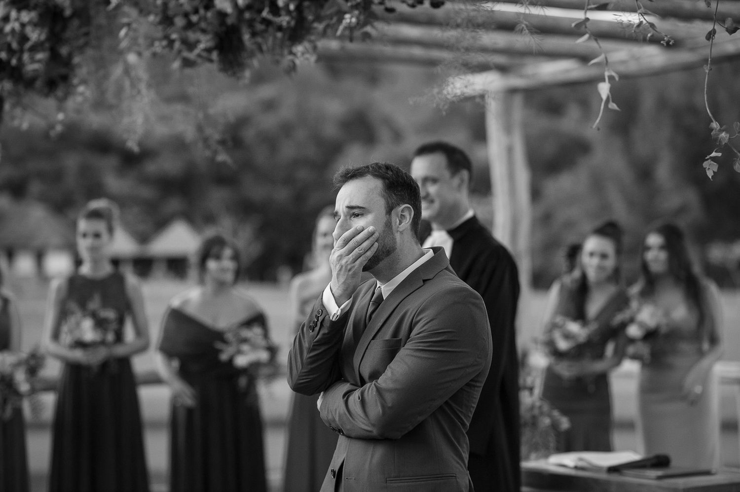 Black and white emotional reaction during outdoor wedding ceremony.