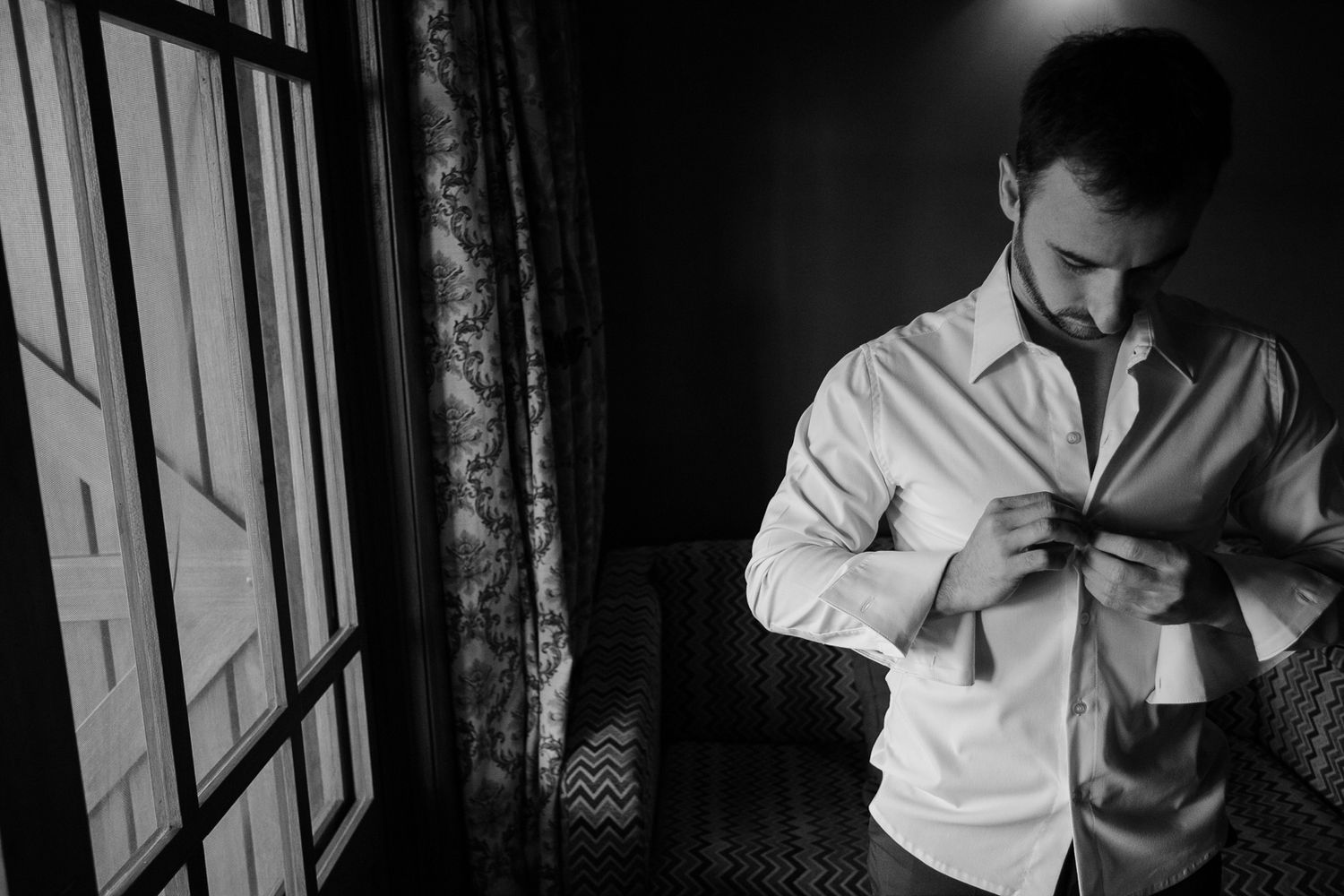 A dramatic black and white image of morning wedding preparation.