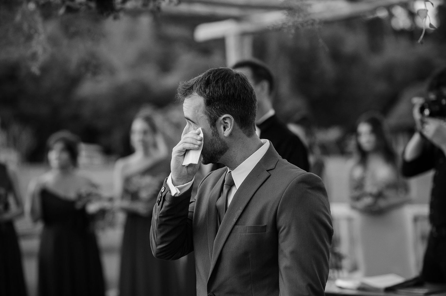Black and white candid moment during an outdoor wedding reception.