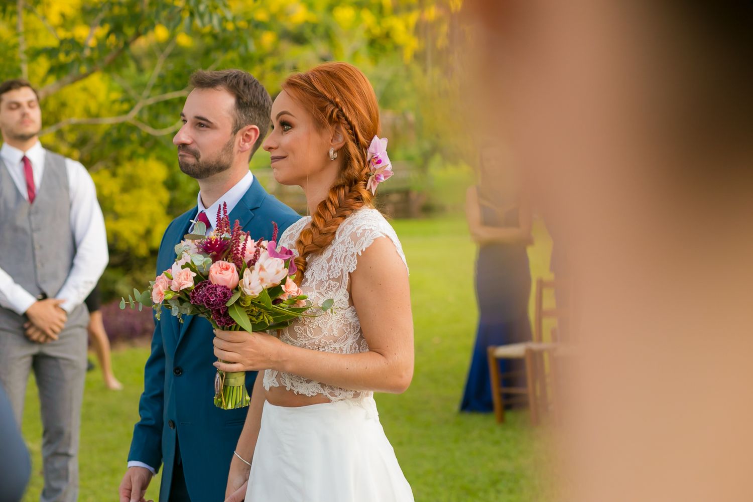 Garden wedding ceremony with floral bouquet against backdrop of autumn trees.