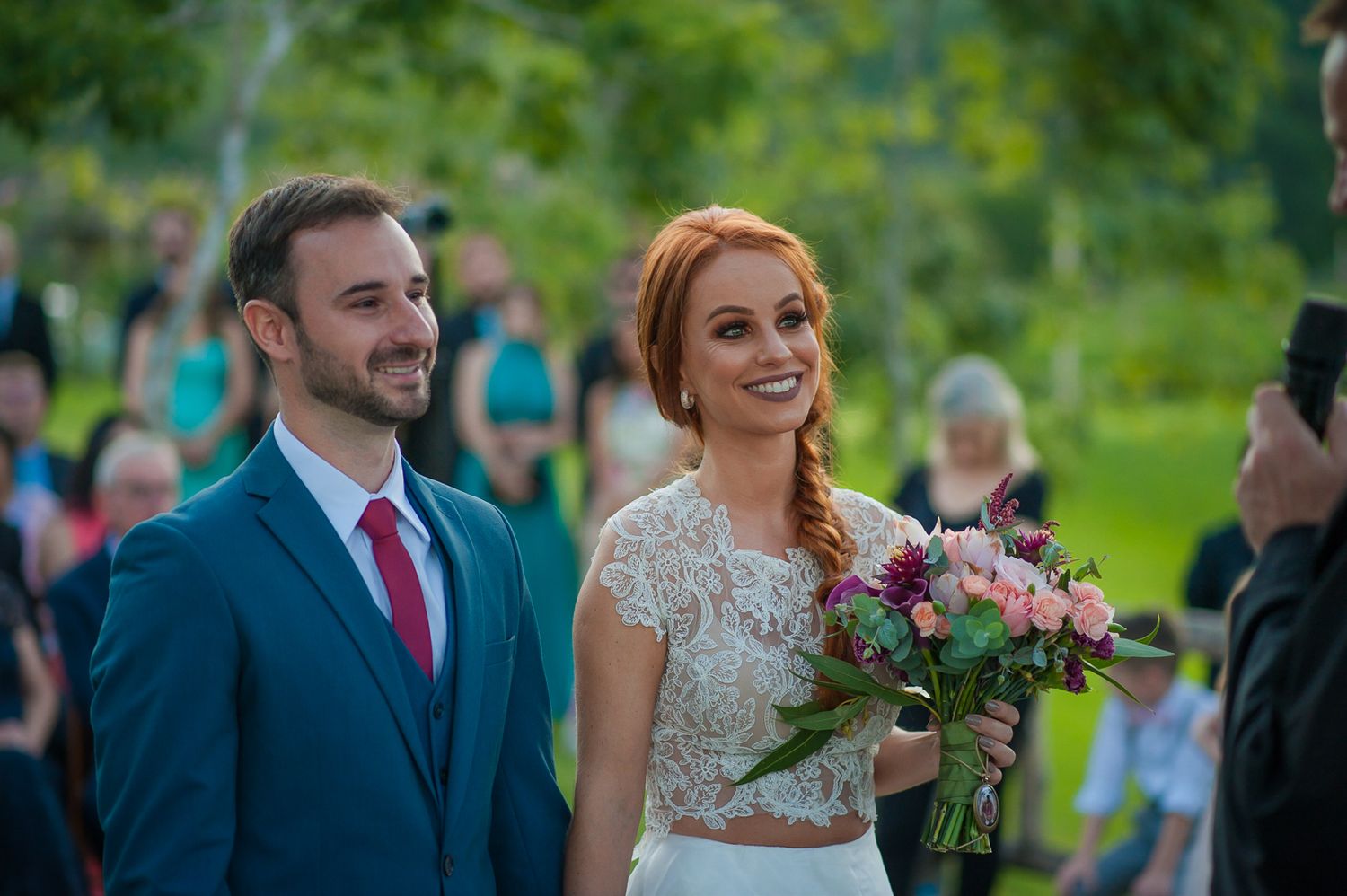 Joyful wedding moment captured outdoors with natural greenery backdrop.