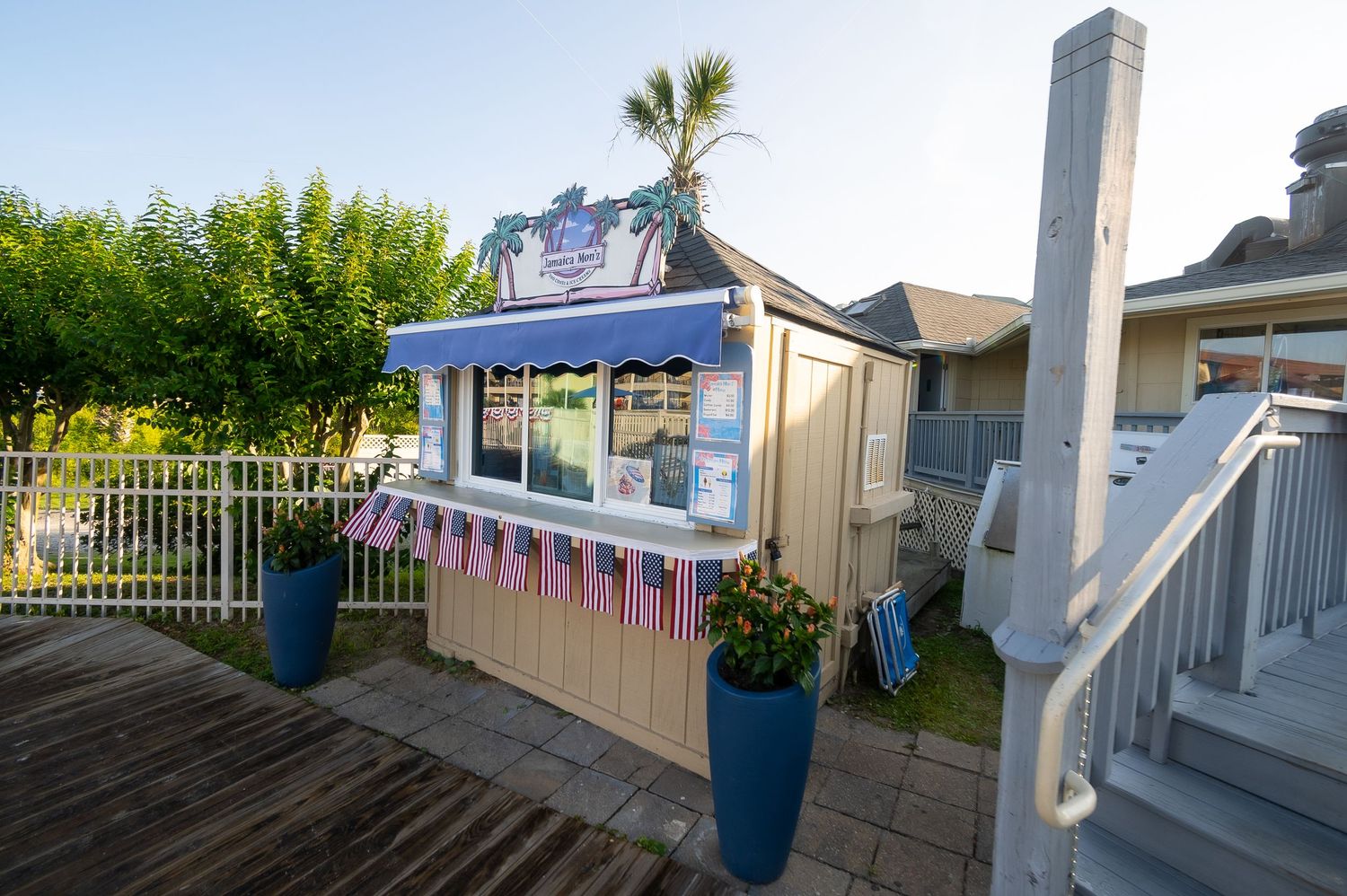 Colorful beachside concession stand with festive bunting on wooden deck.