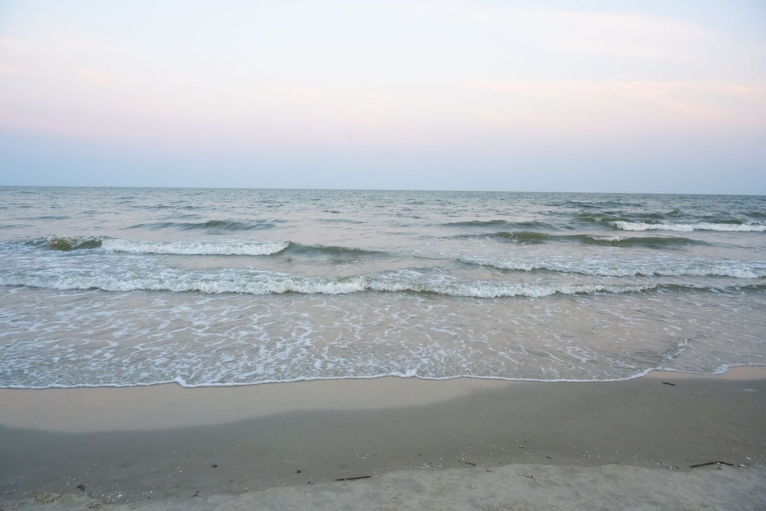 Peaceful seascape with waves breaking on shore at twilight.