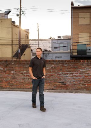 Urban photo shoot on concrete surface with rustic brick wall backdrop.