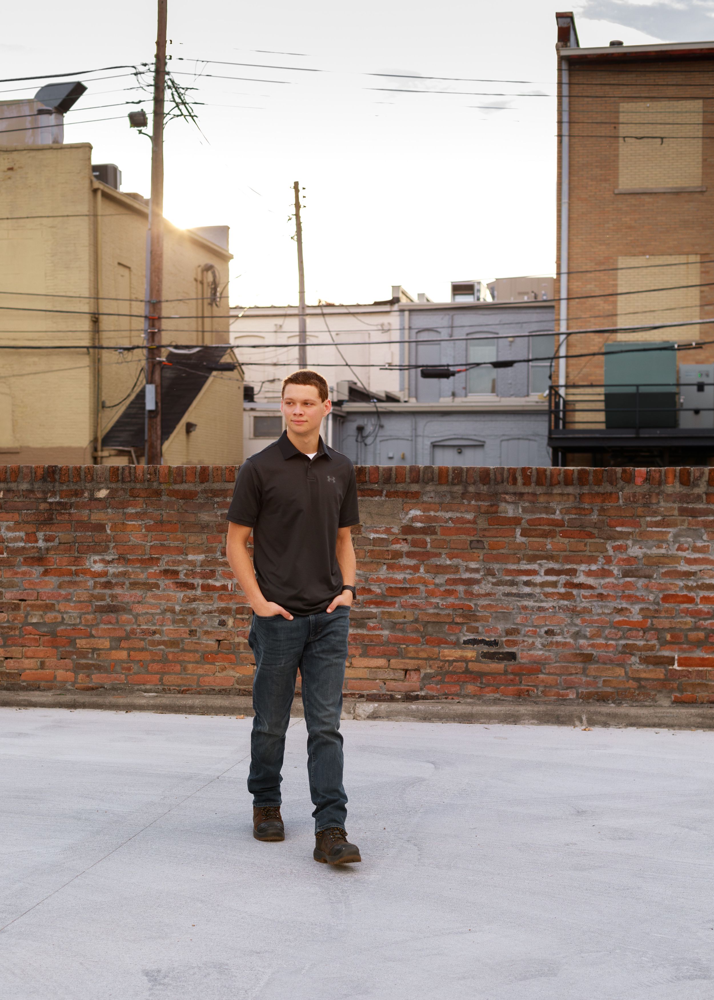 Urban photo shoot on concrete surface with rustic brick wall backdrop.