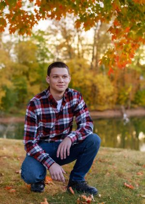 Beautiful fall setting with orange maple leaves and a lake in the background.