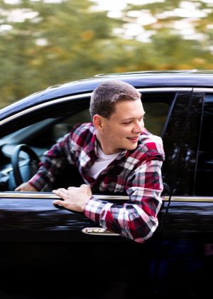 Sequential shots of someone leaning out of black car window wearing plaid shirt.