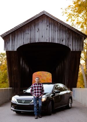 A wooden covered bridge with fall colors visible through the entrance.