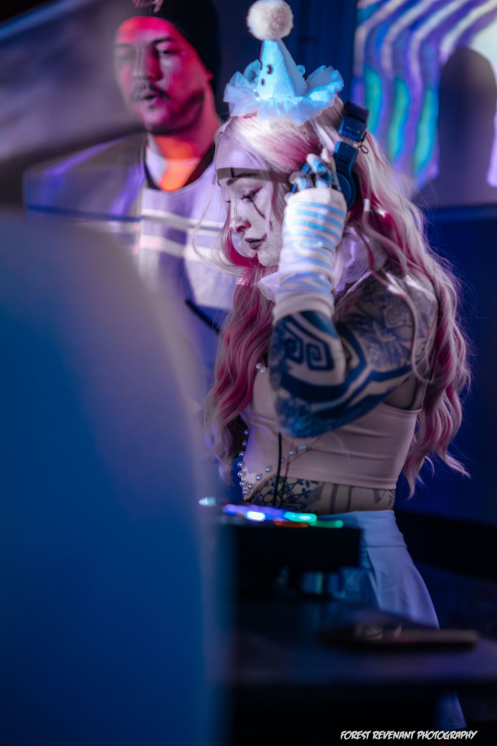 Dynamic performance shot with dramatic pink and blue lighting effects on stage.