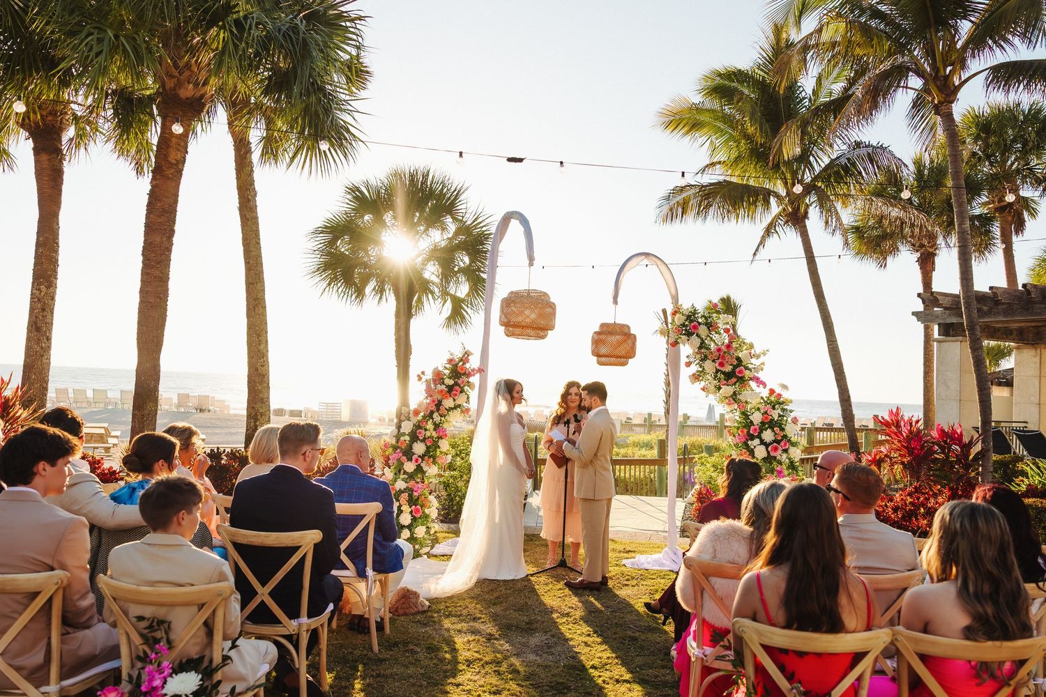 Bride and groom share romantic moment on waterfront staircase overlooking marina at sunset on their wedding day.