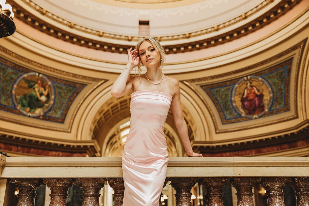 Glamorous fashion photography in an ornate historic building with curved architectural details.