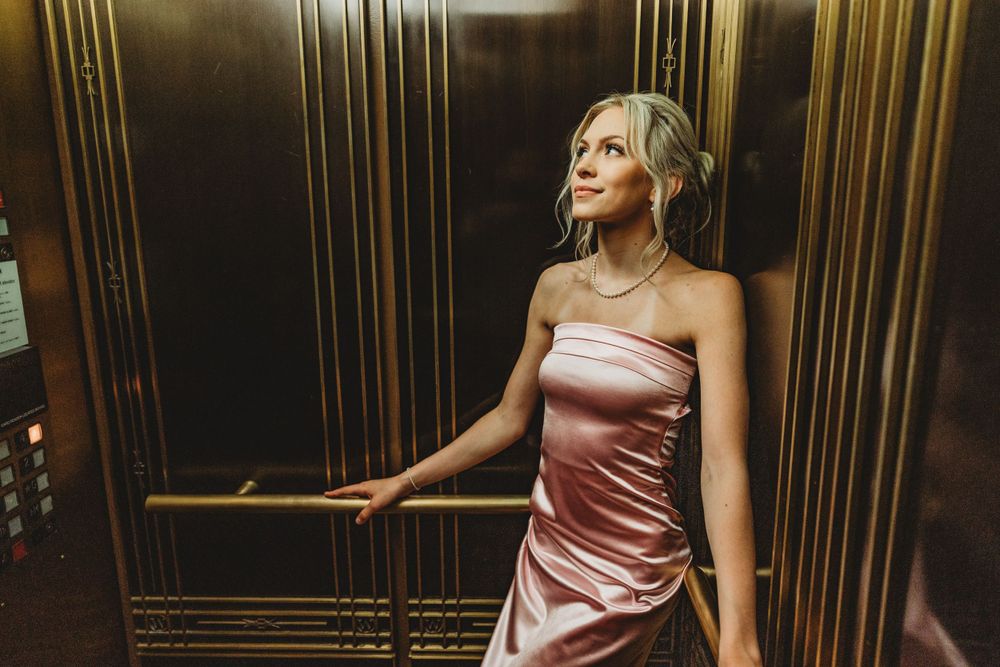 Fashion portraits in an elegant hallway with dramatic lighting and metallic accents.