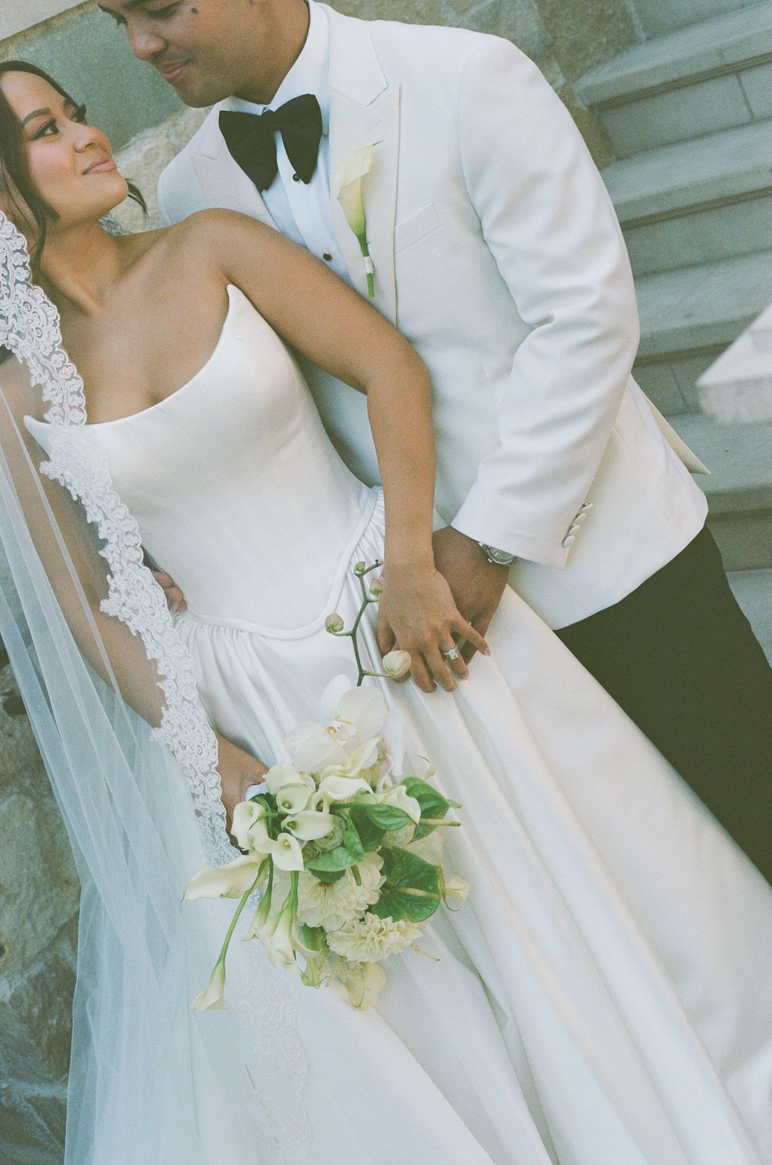 Wedding details flatlay with decorated shoes, invitation and floral elements in black and white.