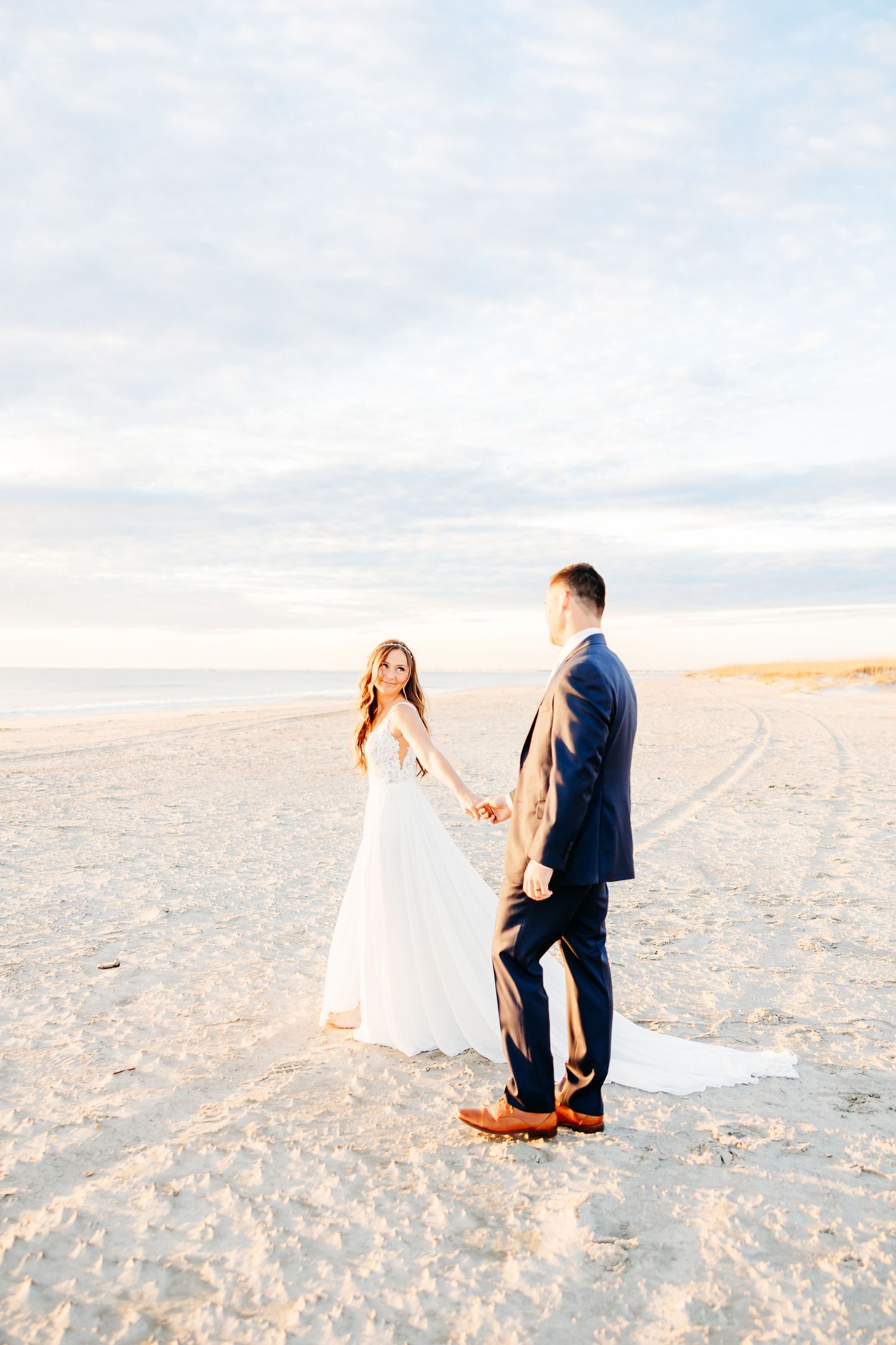 A romantic proposal scene unfolds on a sandy beach at sunset with soft pastel colors in the background.