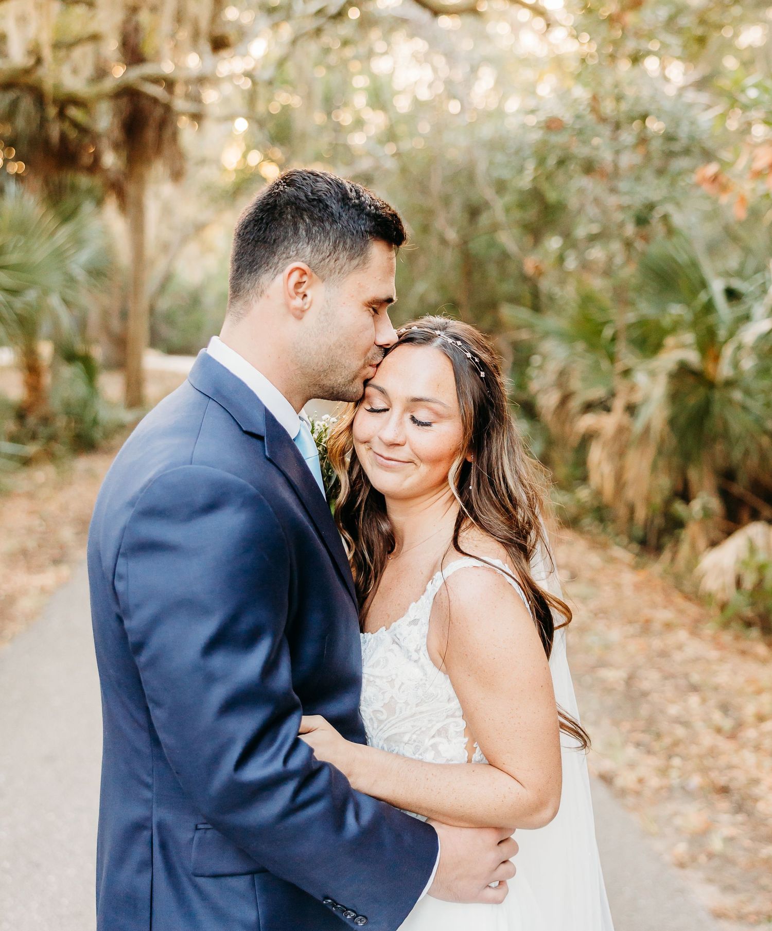 A romantic moment between newlyweds sharing an intimate embrace outdoors in a lush garden setting.