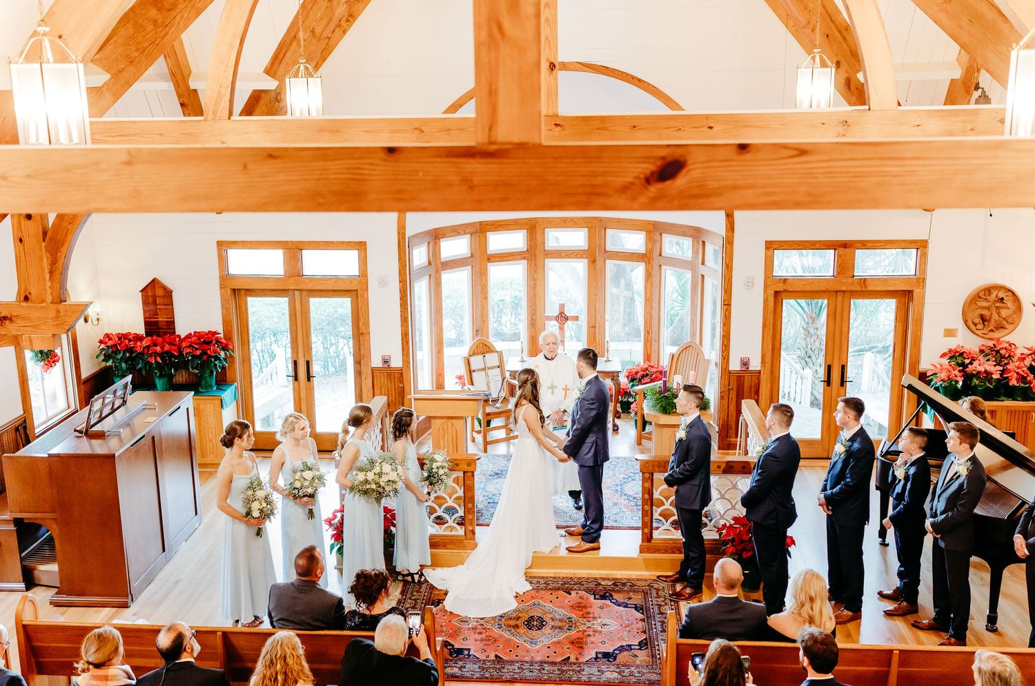 A panoramic view of a bright orange-tinted restaurant interior with diners seated at tables and windows along the wall.