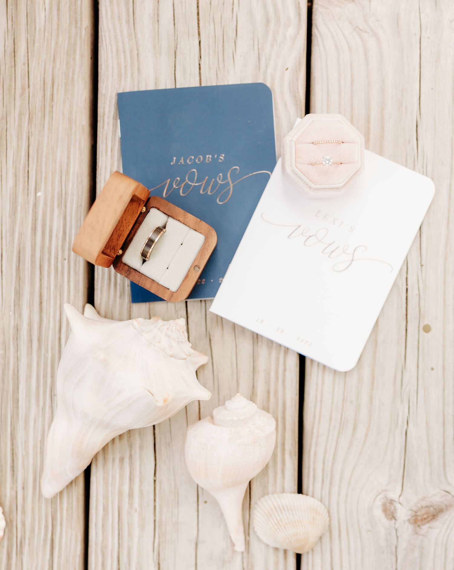 Wedding invitations and stationery scattered on a rustic white wooden surface with a soft, romantic aesthetic.