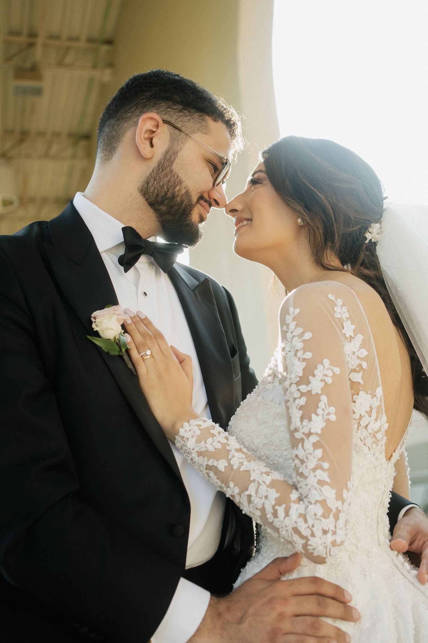 Intimate wedding portrait of couple embracing while sharing tender moment in formal attire.