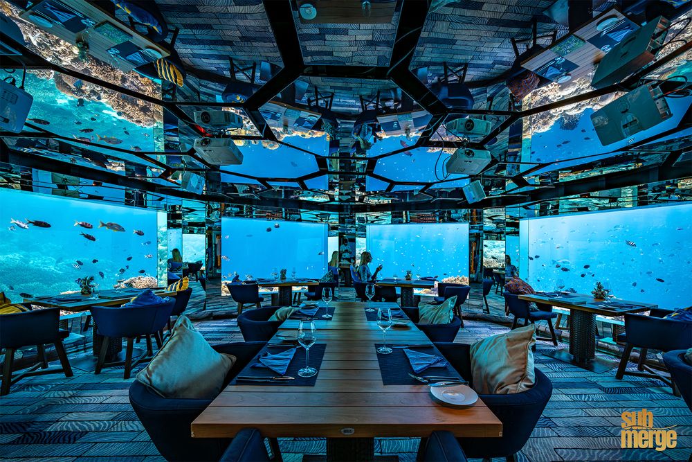 Luxurious underwater restaurant with panoramic ocean views and elegant table settings surrounded by marine life.