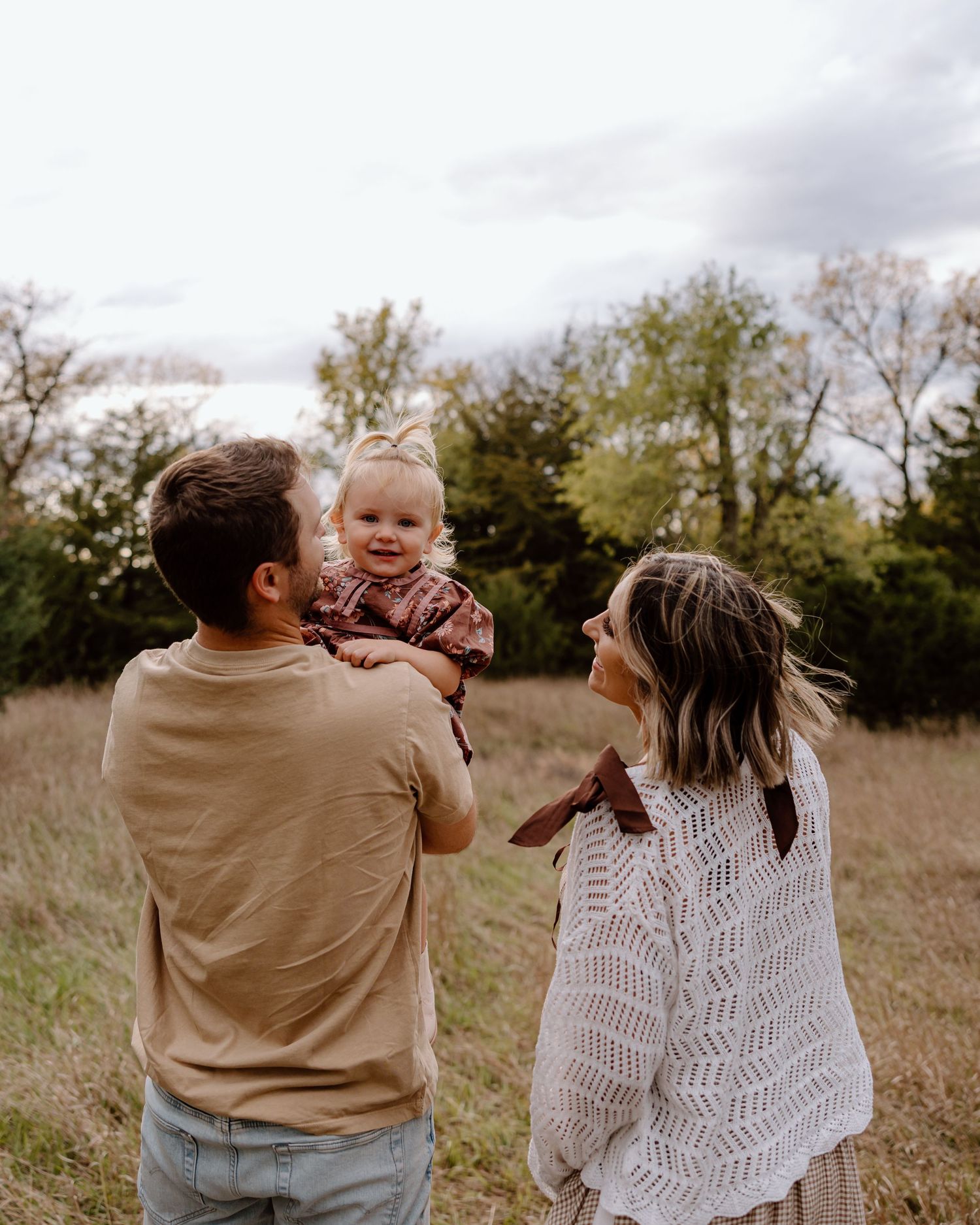 Candid family moments captured during golden hour in an autumn park setting.