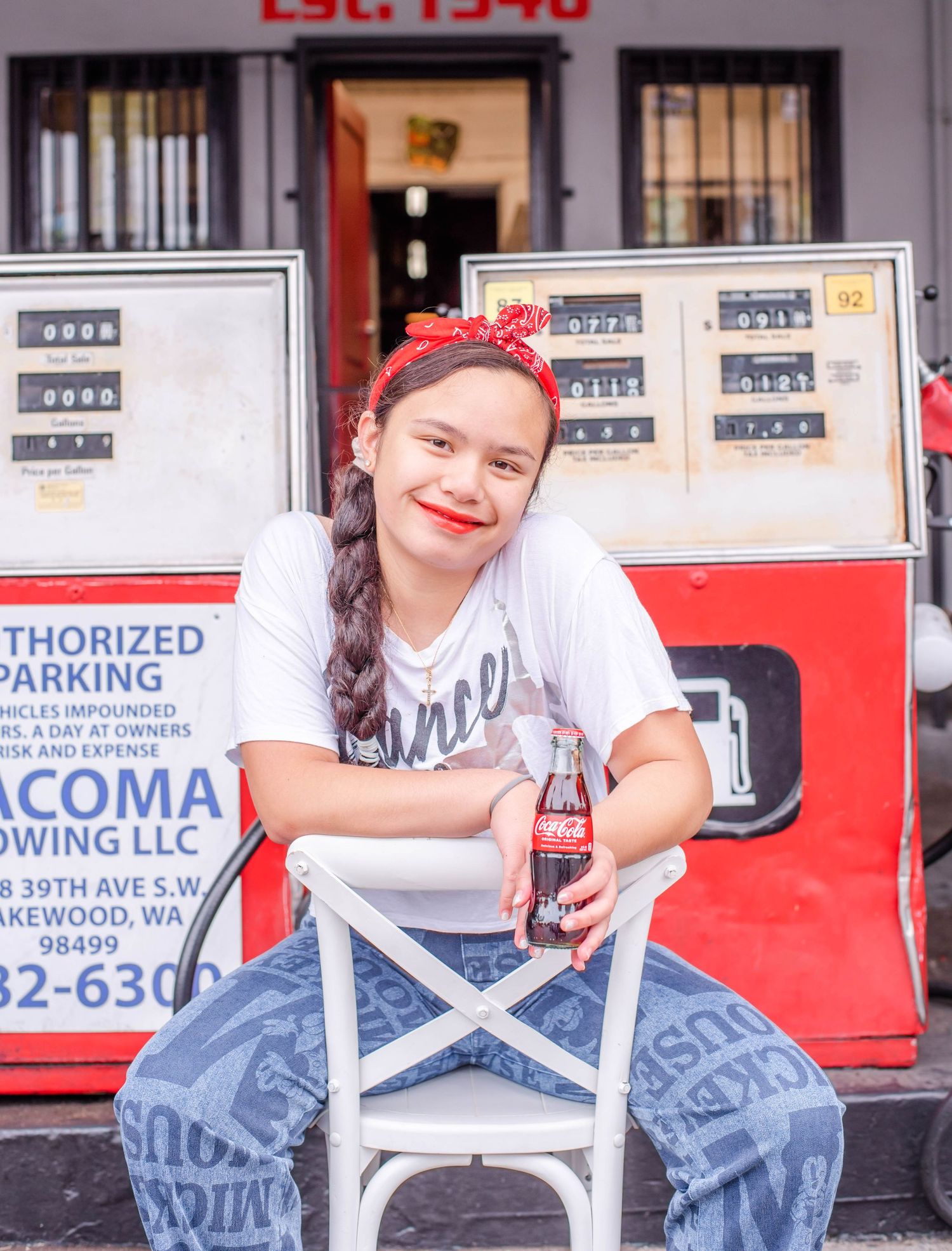Person in casual attire sits on chair near parking meter display.