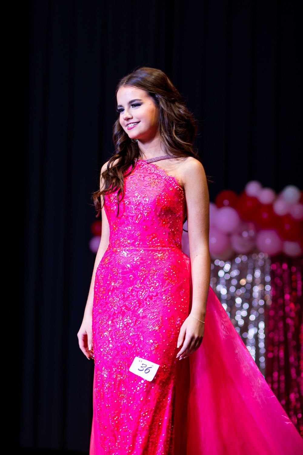 Close-up of fitted hot pink sequined gown with sparkle detail on stage.