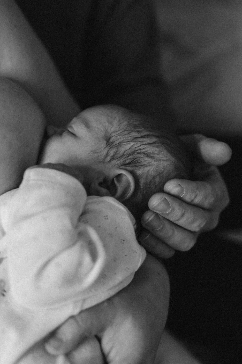 Black and white photo series of small hands gently touching in a nurturing moment.