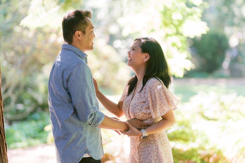 A tender moment captured between a couple in a sunlit garden setting.