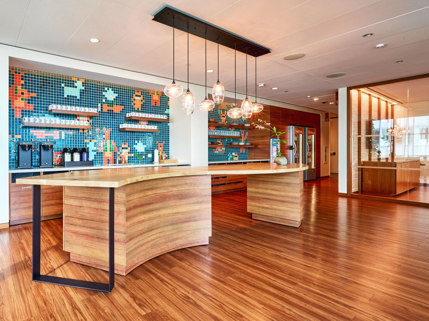 Modern commercial space with hardwood floors and pendant lighting in an open floor plan.