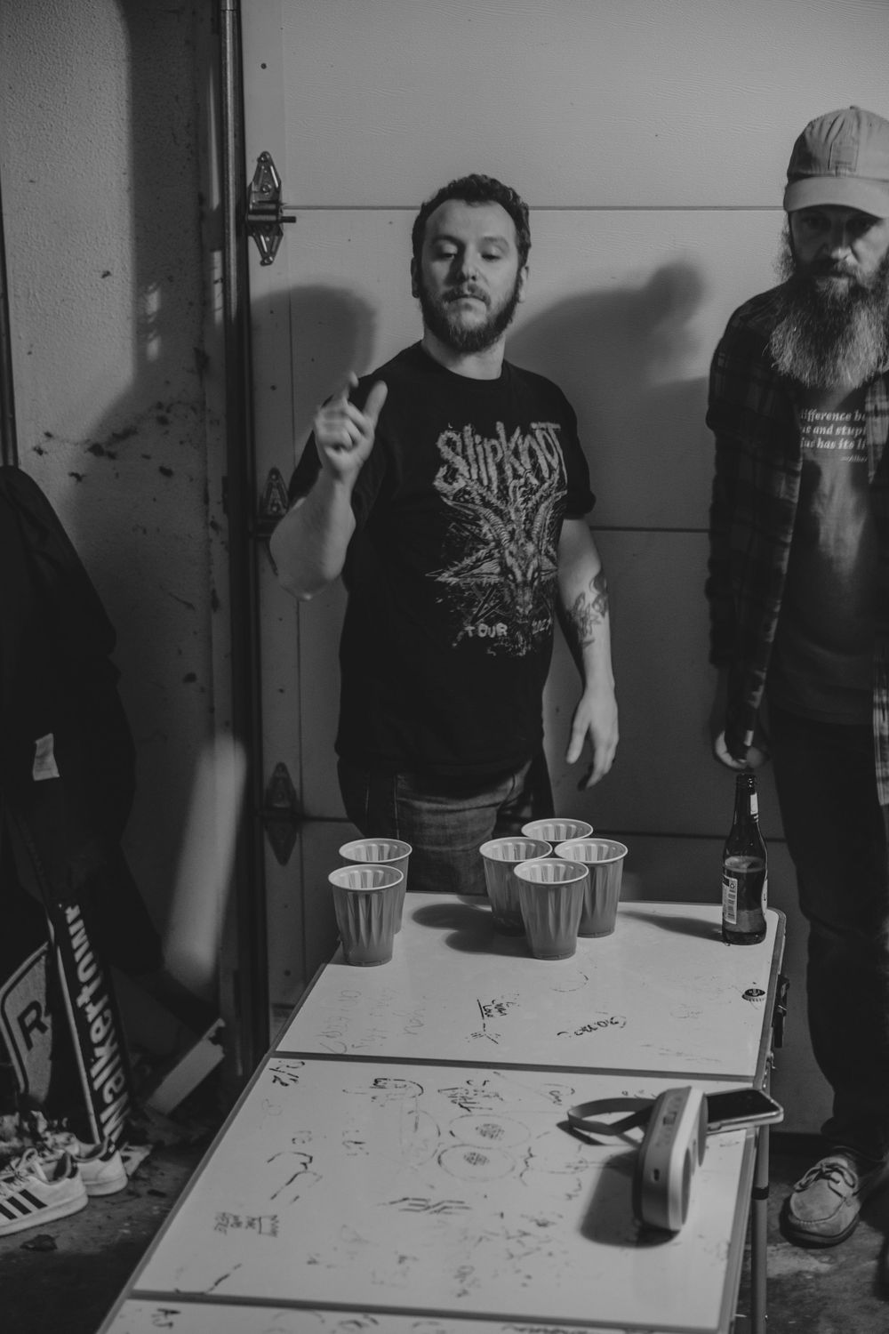 Black and white photos of people gathered around a table wearing band t-shirts.