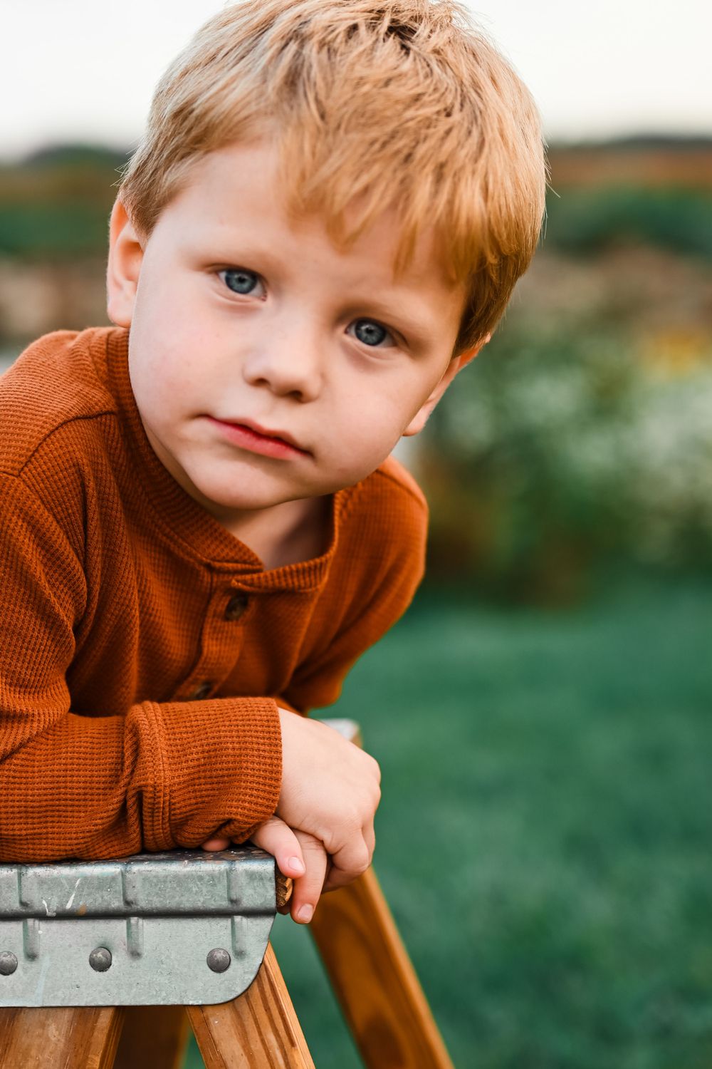 Little boy hanging over ladder at Prophetstown State Park.
