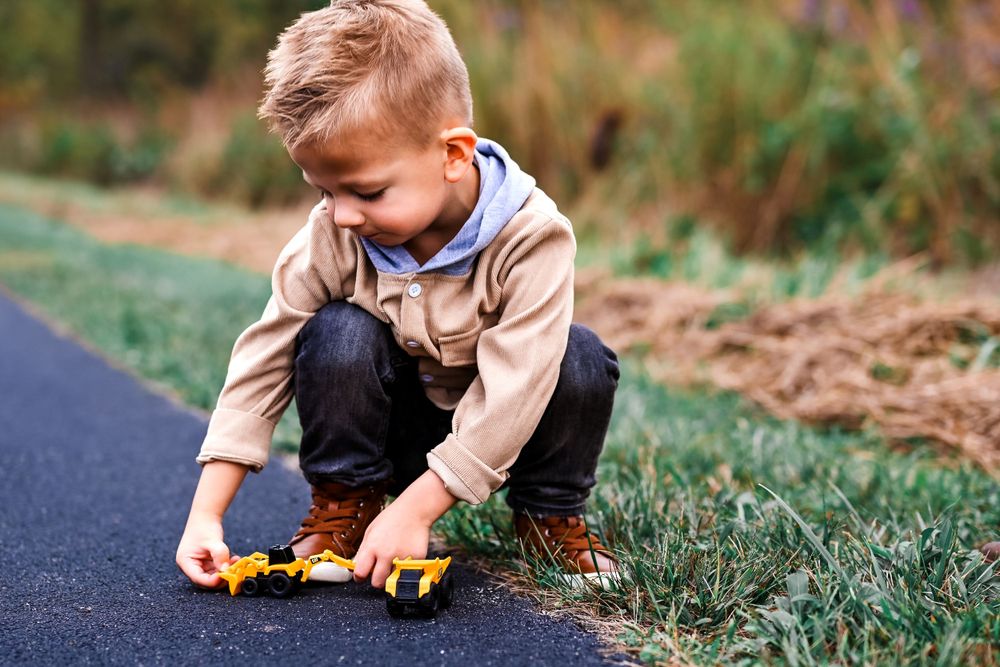 Little boy playing with his yellow truck.