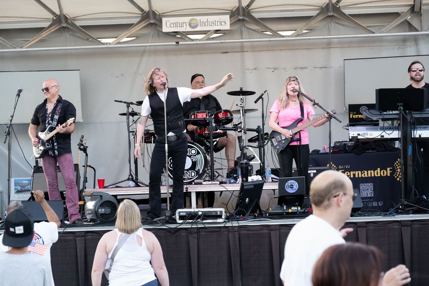 Musical performance on elevated stage with crowd visible below.