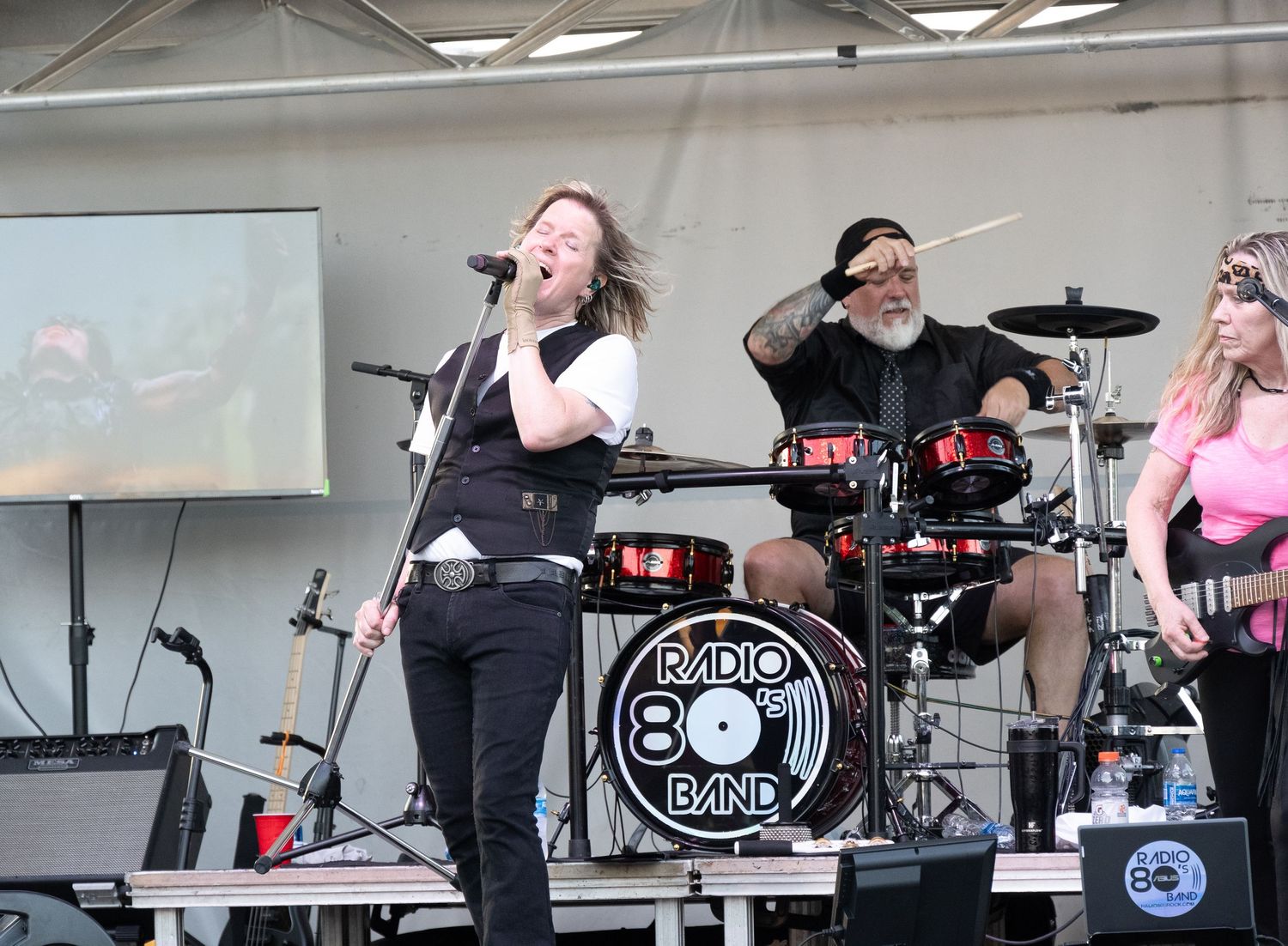 Radio 80s Band performs live with full ensemble on outdoor festival stage.