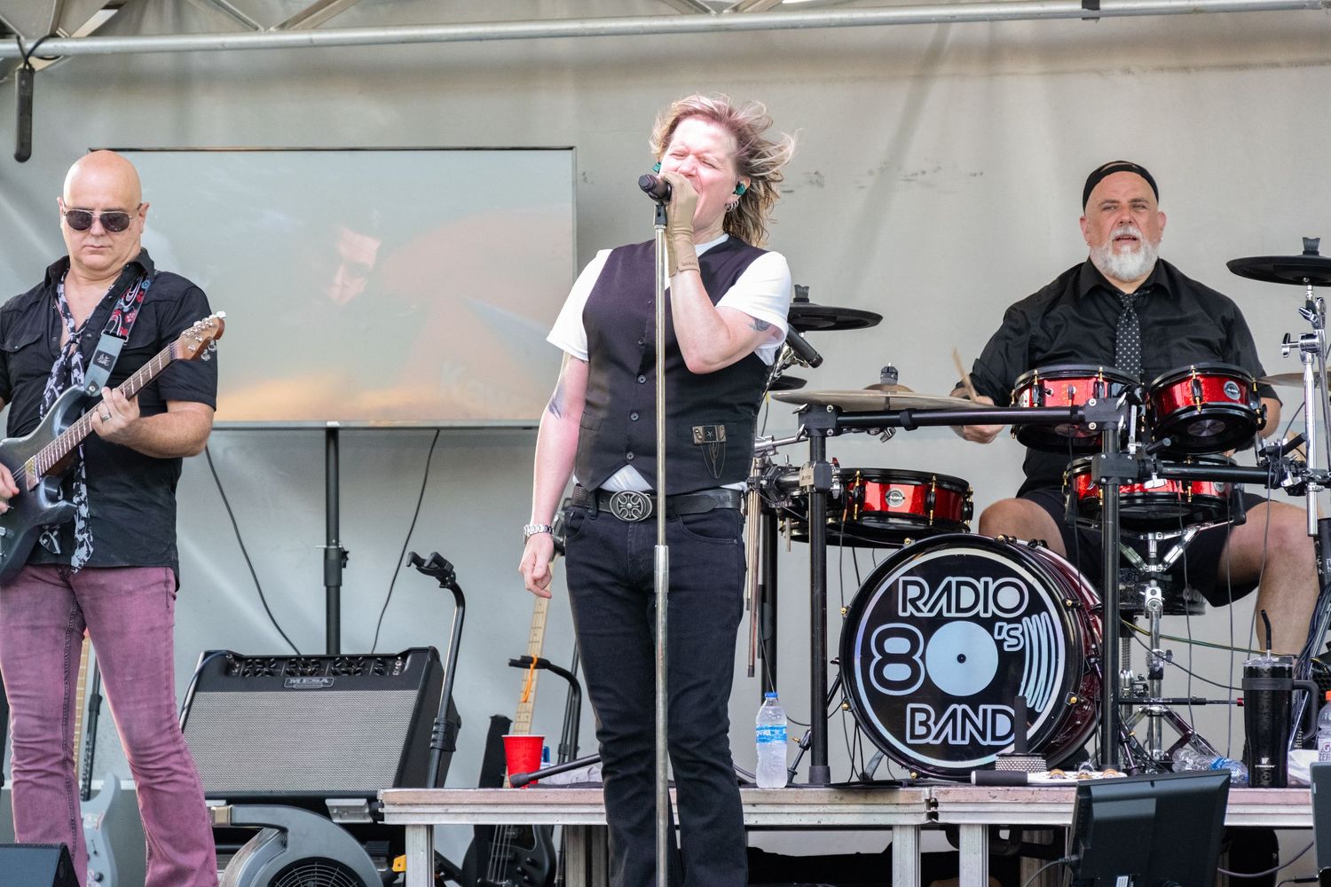 Musicians playing on stage with a distinctive Radio 801 drum kit and performance setup.
