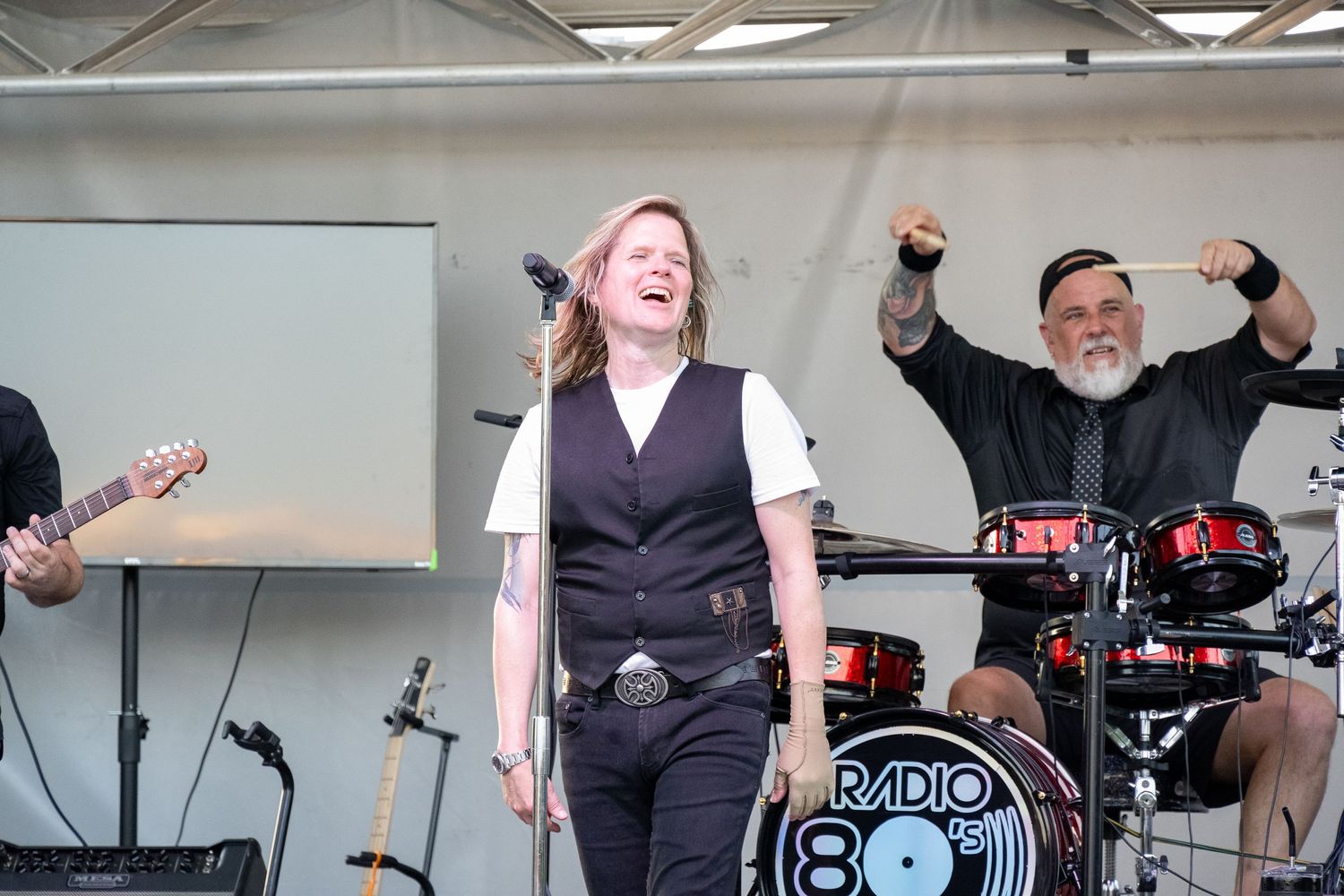 Energetic performance moment captured on stage with animated musicians and Radio 801 drum kit.