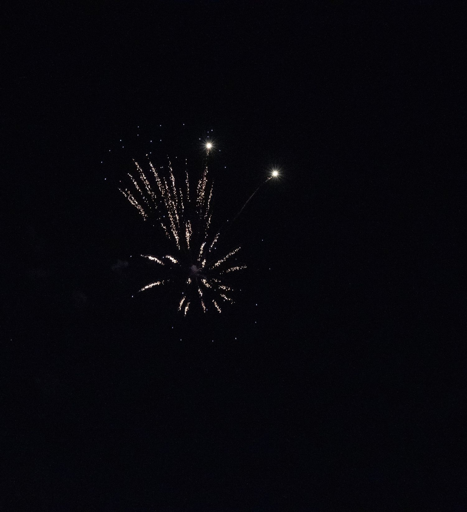 Small silver firework burst with bright stars shining in the background.