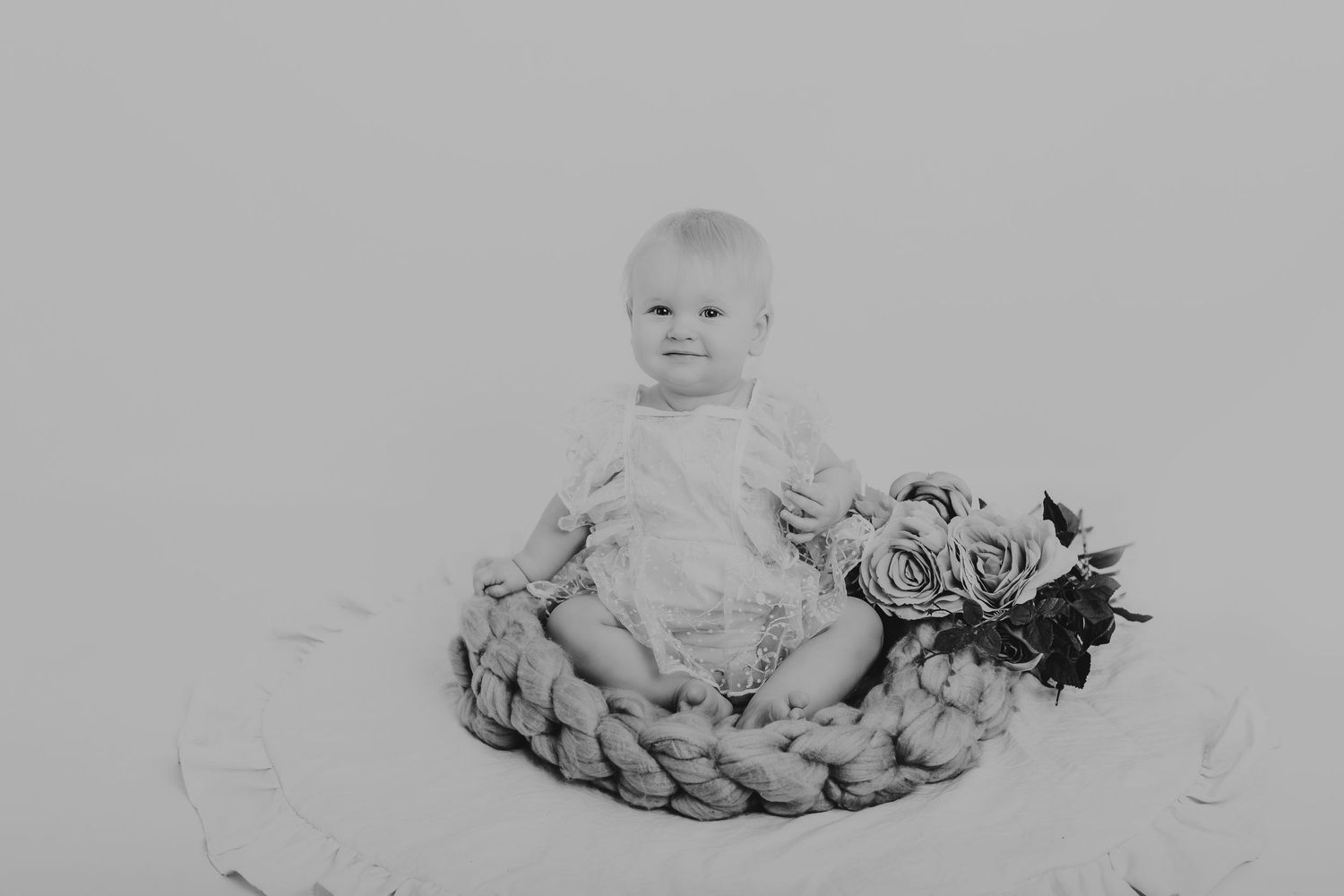 Black and white photo of a baby surrounded by delicate floral arrangements. Photographer. Hull. East Yorkshire. Photography