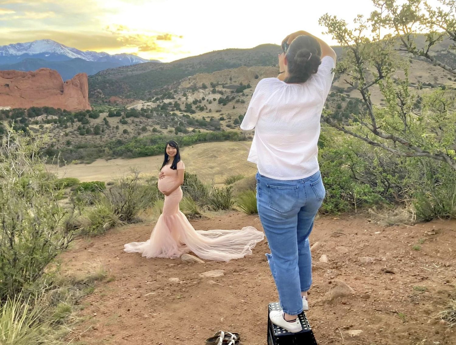woman taking photo of pregnant woman.  Maternity photoshoot
