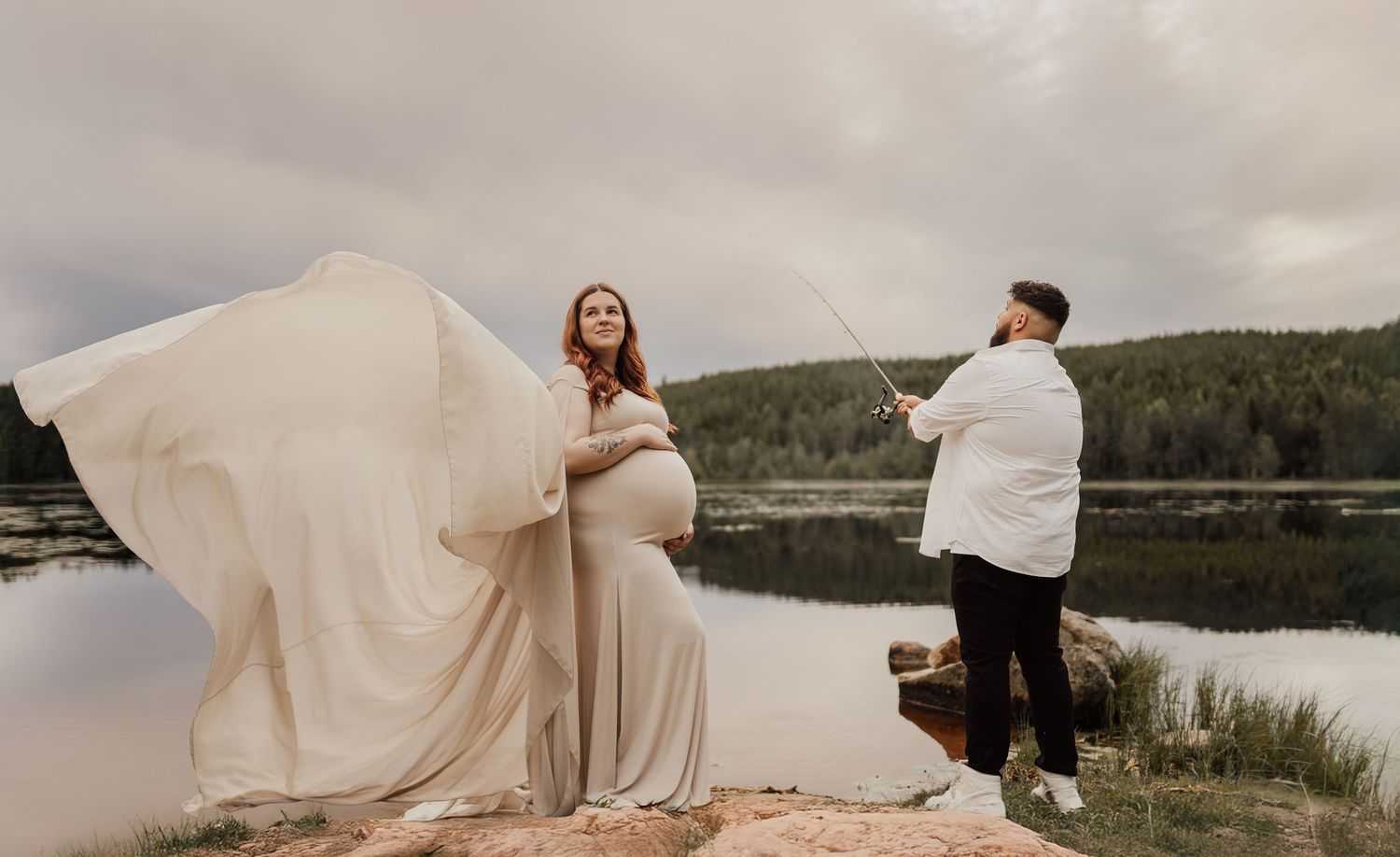 A couple shares an intimate moment at sunset in a field with dried plants.