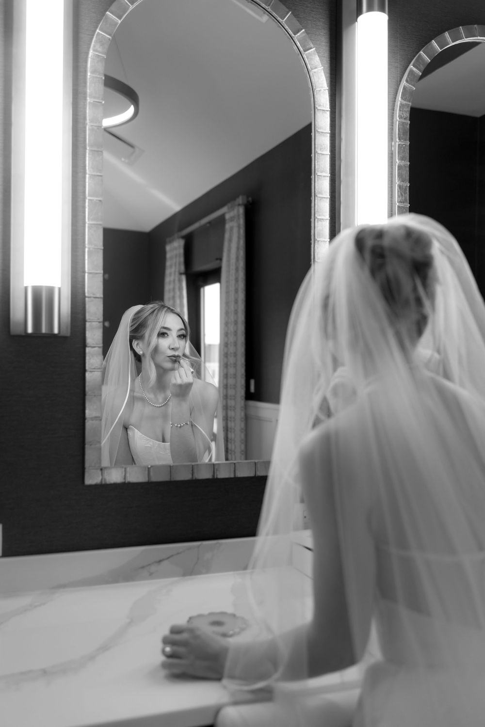 Reflective moments captured in bathroom mirrors during wedding preparations.