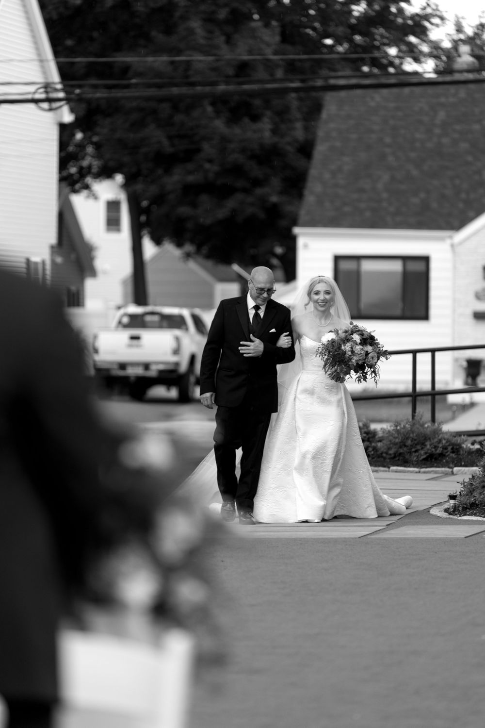 Black and white wedding portraits taken outside a traditional white house.