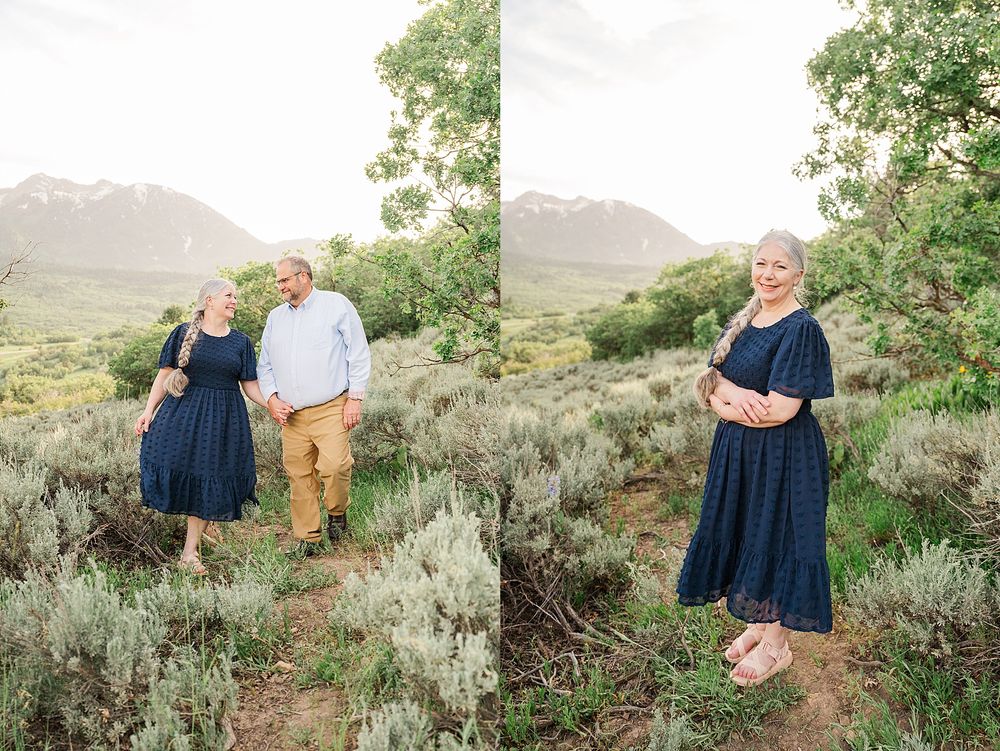 Two people pose together in sage brush landscape with mountains and trees in background.