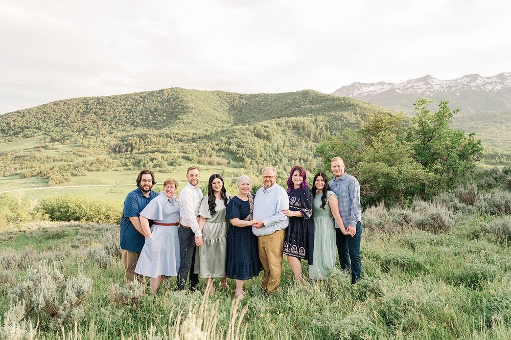 Group photo of wedding guests gathered in the Utah mountains with scenic rolling hills.