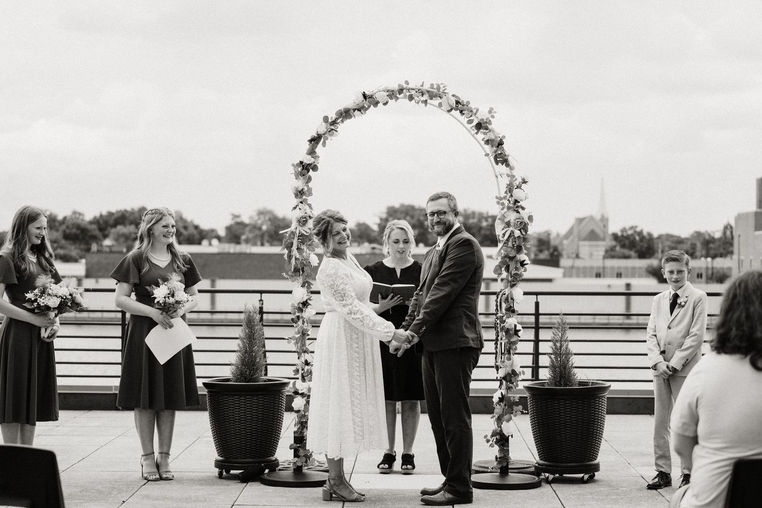 Reception celebration with couple in formal attire entertaining guests in casual venue setting.